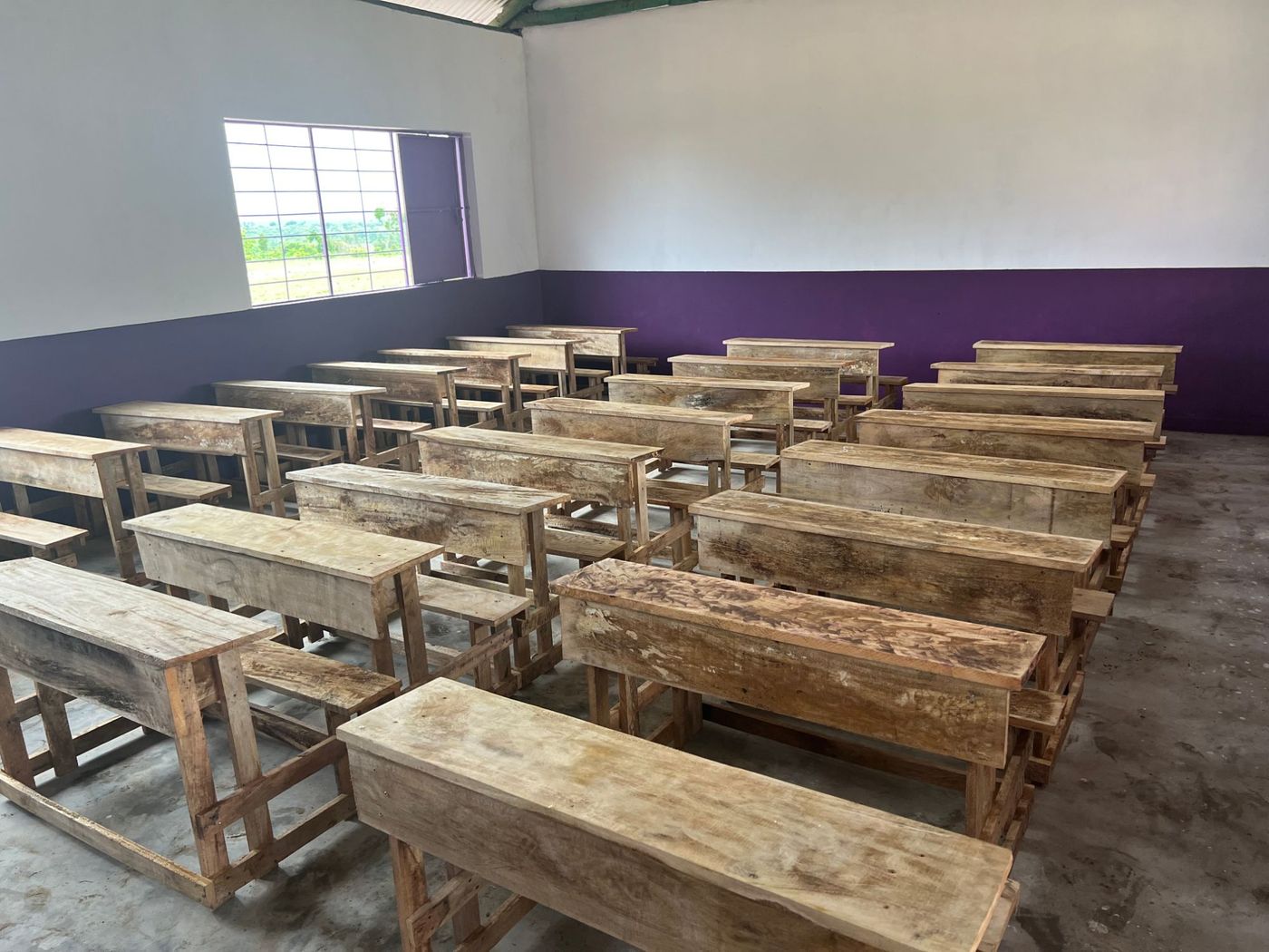 Rows of handmade wooden desks in a new classroom