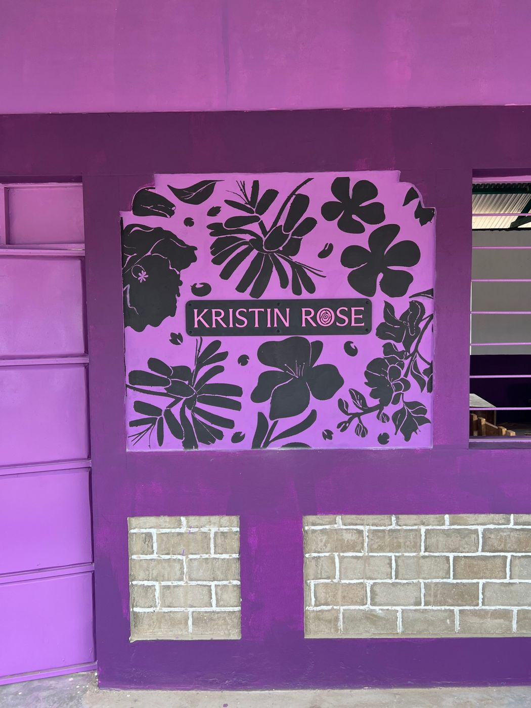 Painted floral mural on the school wall with a Kristin Rose sign