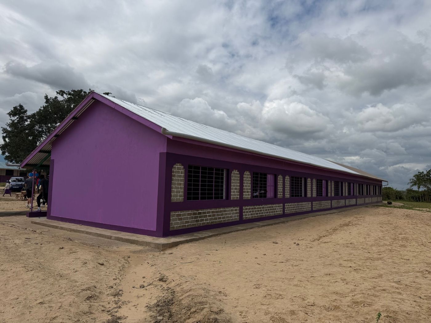 A newly finished schoolhouse with a metal roof and painted walls